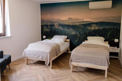斯雷布纳古拉Apartamenty Koziołek的一间卧室设有两张床,墙上挂着一幅画