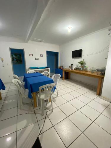 卡马穆Pousada o Paraiso的一间配备有蓝色桌子和椅子的用餐室