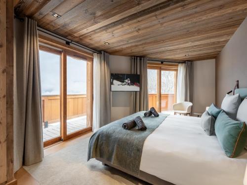 谷雪维尔Chalet Courchevel 1550, 7 pièces, 14 personnes - FR-1-562-47的一间卧室设有一张大床和一个大窗户