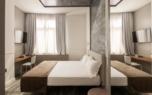 罗马内葛诺酒店的小房间设有床和2个窗户