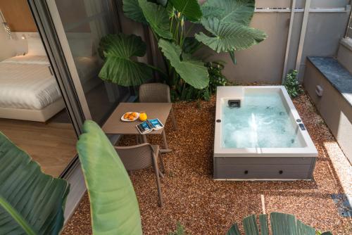 雅典Athens Hill Luxury Apartments的一个带桌子和植物的房间的热水浴缸