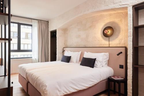 奥斯坦德Rosa Hotel的一间卧室配有一张带白色床单的大床