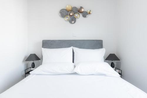 库鲁塔KOUROUTA BEACH HOUSE的卧室配有白色的床铺和白色的枕头