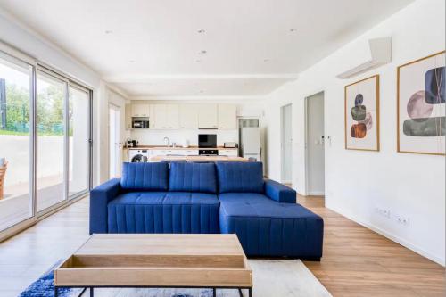 昂蒂布Villa Constance - Antibes的一间带蓝色沙发的客厅和一间厨房