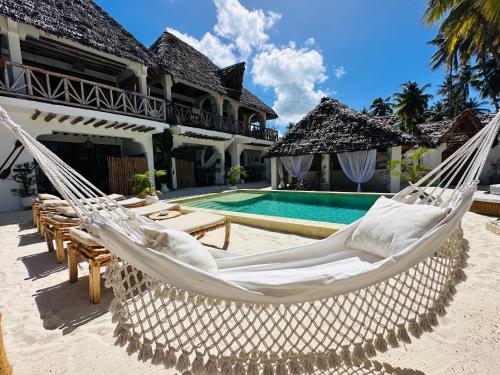 江比阿Olamanga Beach Villa的一个带吊床和游泳池的别墅