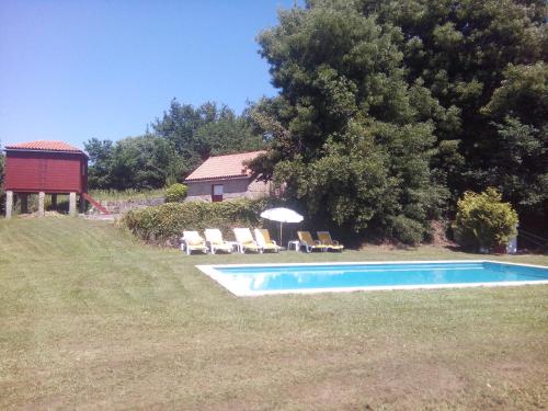 Paço de Sousa库塔达福特奥卡达农家乐的庭院内的游泳池配有椅子和遮阳伞