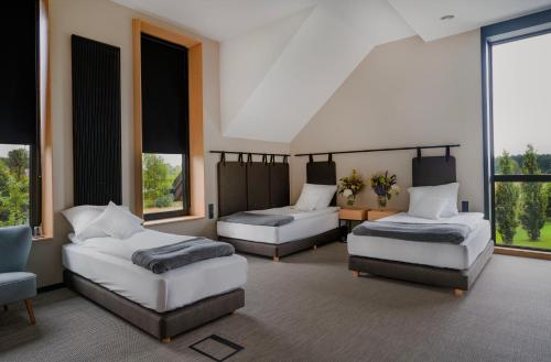 GrójecKarma House Gościeńczyce的客房设有两张床、一张沙发和窗户。