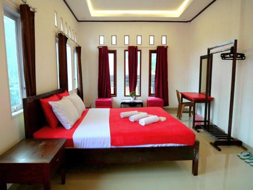 兰特包The Sanduk Homestay的卧室配有红色和白色的床和2条毛巾