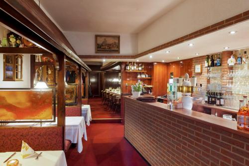 汉诺威Restaurant Donau的餐厅设有酒吧,配有桌椅