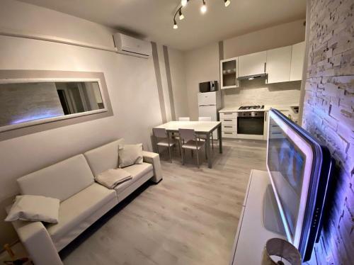 洛萨皮内塔[SolMare] Apartments - Private parking - Pool的一间带白色沙发的客厅和一间厨房
