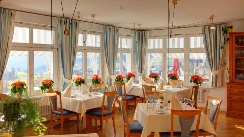 伦茨基希JUFA Hotel Schwarzwald的用餐室设有桌椅和窗户。