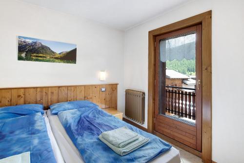 利维尼奥Appartamento Bormetti Paolo Sara的一间卧室设有蓝色的床和窗户。