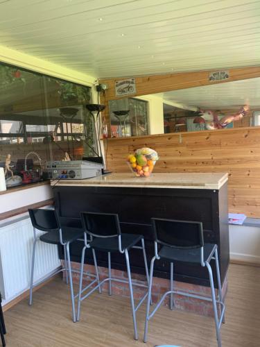 布莱克浦Family Holiday Home的厨房配有带椅子和一碗水果的柜台
