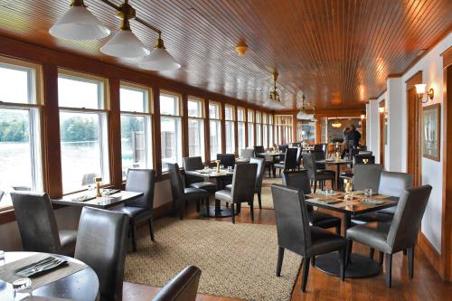 DepositChestnut Inn at Oquaga Lake的用餐室设有桌椅和窗户。