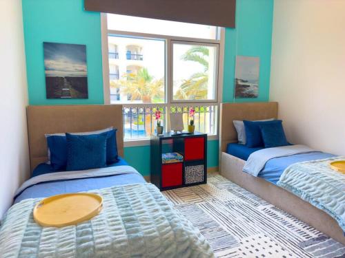 阿布扎比Luxury Golf View For Family 203A3的一间卧室设有两张床和两个窗户。