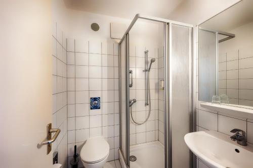 柏林Enjoy Hotel am Studio的带淋浴、卫生间和盥洗盆的浴室