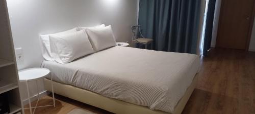 米尔芳提斯城Apartamentos Naturalis的一间卧室配有带白色床单和枕头的床。