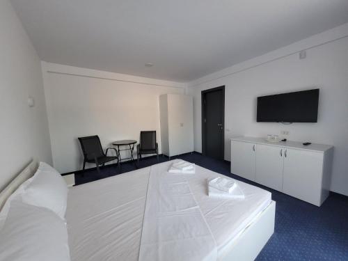 曼加利亚Laguna Grey的酒店客房设有一张床和墙上的电视
