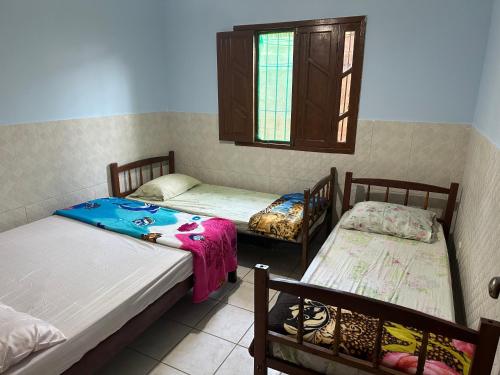 瓜拉派瑞Casa do SOL的客房设有两张床和窗户。