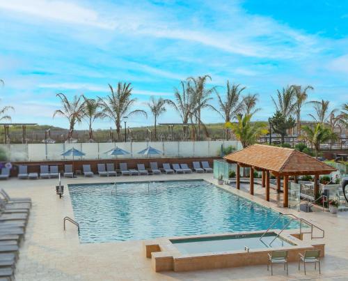 大洋城大洋城假日酒店的一个带椅子和棕榈树的度假村游泳池