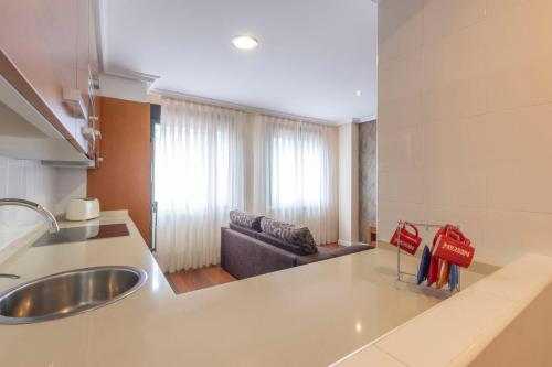 利亚内斯Apartamentos Verdemar (VUT)的一个带水槽的厨房和一张沙发
