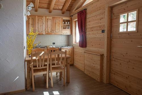 摩德纳迪-坎皮格里奥Chalet Camping Faè 2的厨房配有木制橱柜和桌椅