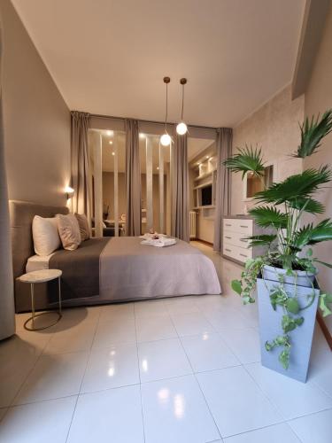 罗马Roman Holidays House Monteverde的一间卧室配有一张床和盆栽植物