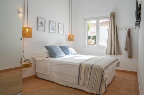休达德亚Casa Menorquina centro Ciutadella的一间卧室设有一张床和一个窗口