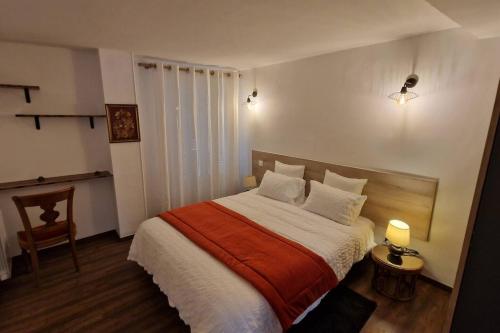 蒂耶里堡Le Cygne的一间卧室配有一张带橙色和白色毯子的床