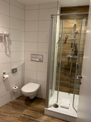 锡格堡凯撒霍夫酒店的一间带卫生间和玻璃淋浴间的浴室