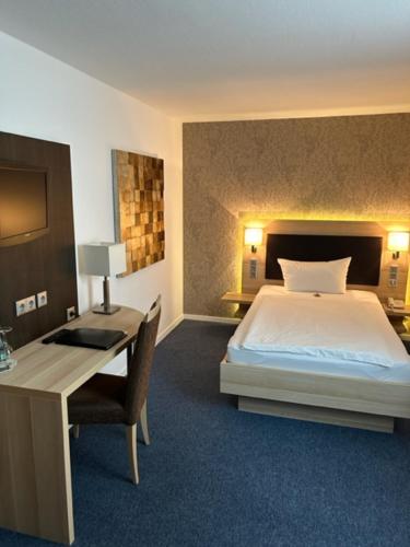 锡格堡凯撒霍夫酒店的一间卧室配有一张床、一张书桌和一张书桌
