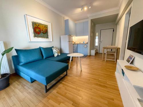 雅典Iris的客厅配有蓝色的沙发和桌子