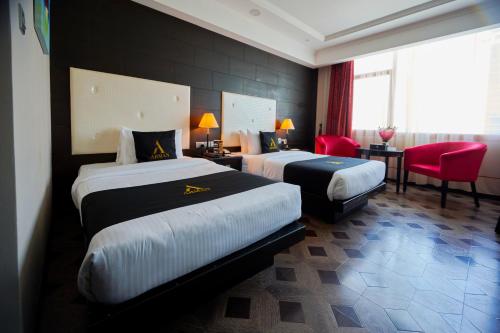 麦纳麦Arman Hotel Juffair Mall的酒店客房,设有两张床和红色椅子