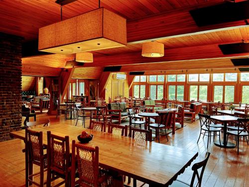 威尔明顿NewVida Preserve的餐厅设有木桌、椅子和窗户。