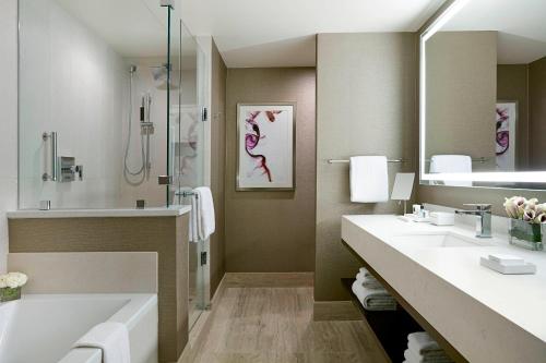 布卢明顿美国明尼阿波利斯商城JW万豪酒店的浴室配有2个盥洗盆、浴缸和淋浴。