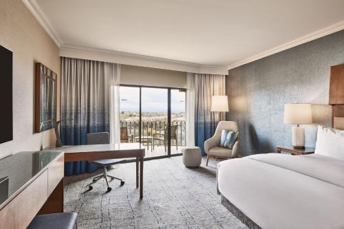 土桑The Westin La Paloma Resort & Spa的酒店客房带一张床铺、一张书桌和一间卧室