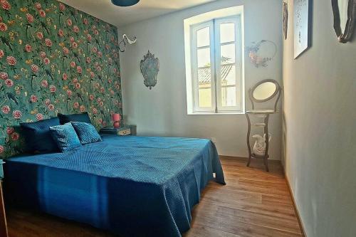 VilledubertDomaine VILLECARLA的一间卧室配有一张蓝色的床和花卉墙