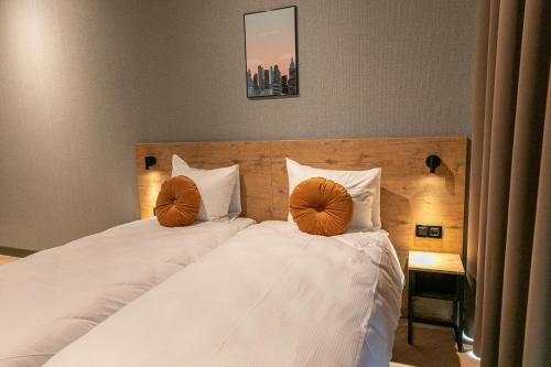 赞丹Distrikt Hotels Amsterdam Zaandam的一间卧室配有两张带橙色枕头的床。