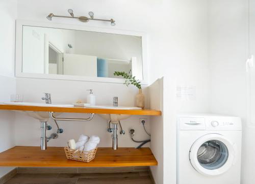 卡兰博希Apartamento Calan Bosch, Ciutadella的一间带水槽和洗衣机的浴室