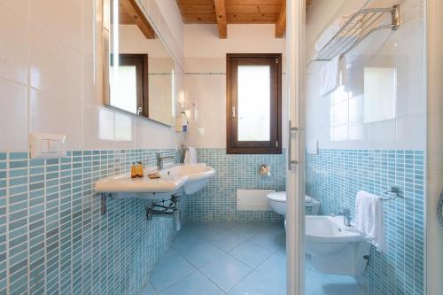 维拉西米乌斯棕榈乡村酒店的蓝色瓷砖浴室设有水槽和卫生间