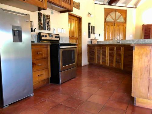 Englishmanʼs BayParrot Estate Villa的厨房配有不锈钢冰箱和橱柜
