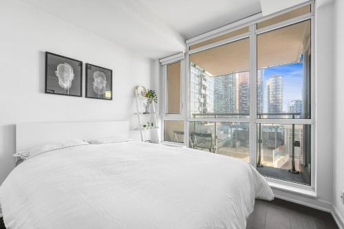 多伦多Heart of Downtown Toronto!的卧室设有白色的床和大窗户