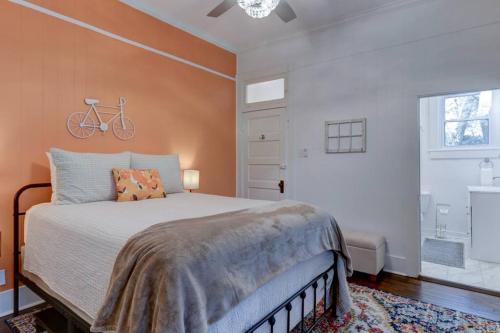 温泉城NEW! Orange Street Downtown Cottage的卧室配有一张床,墙上有自行车