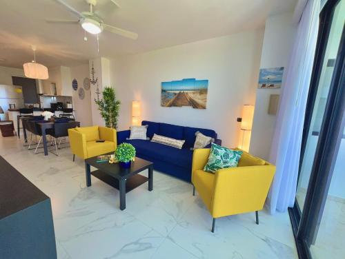 蓬塔卡纳Cana Rock Star, Apartamento Lujo Vista Golf Infinity Pool A-410的客厅配有蓝色的沙发和黄色的椅子
