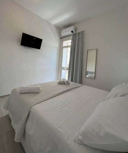 波萨达Central Rooms Posada的白色的卧室设有床和窗户