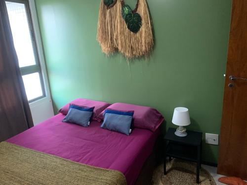 若昂佩索阿Luxor Tambaù的一间卧室配有一张带紫色床单的床和窗户。
