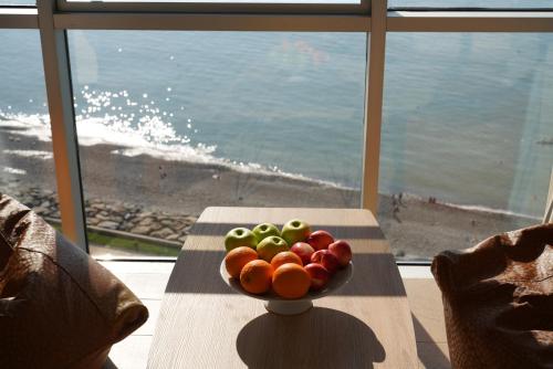巴统RUMI Hotel的窗户前的桌子上放着一碗水果
