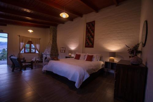 万卡约Tuki Llajta - Pueblo bonito Lodge的一间卧室设有一张大床和一个大窗户