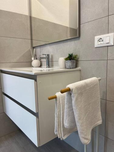波萨达Central Rooms Posada的浴室配有盥洗盆、镜子和毛巾