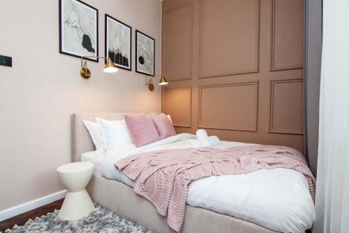 海乌姆Cztery Czaple的一间卧室配有一张带粉色和白色毯子的床